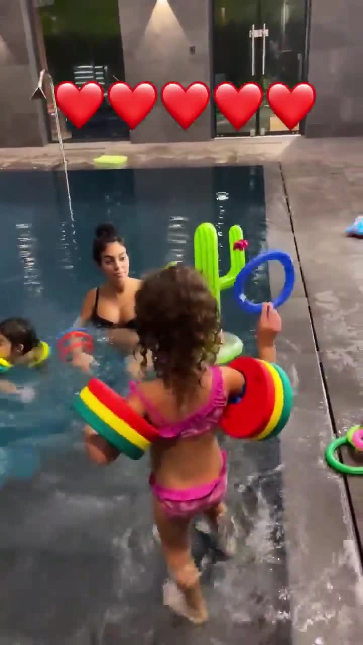怀孕的乔治娜和孩子在游泳池玩耍